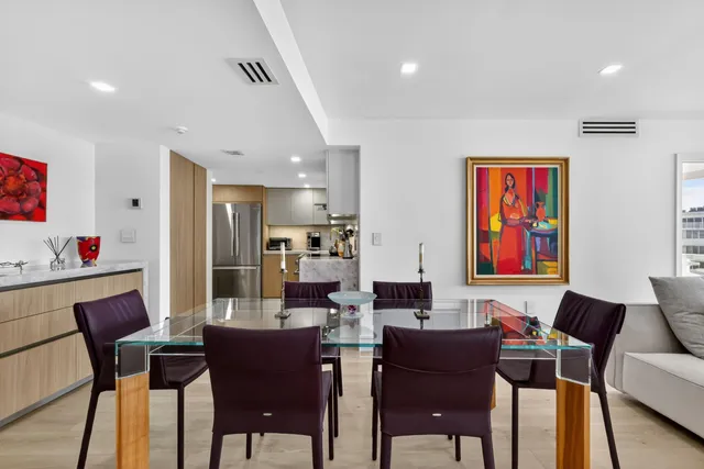 a living room with furniture kitchen view and a wooden floor