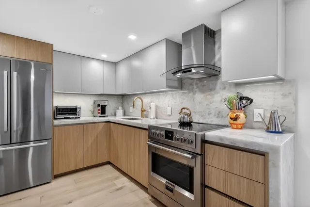 a kitchen with stainless steel appliances granite countertop a sink stove and refrigerator