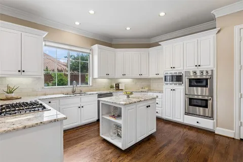 a kitchen with a stove sink and cabinets