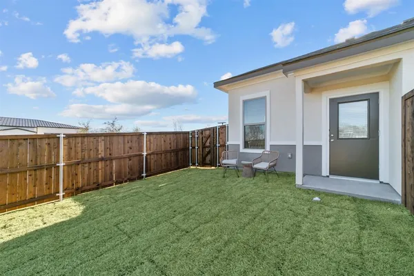a view of a backyard with wooden fence and a bench