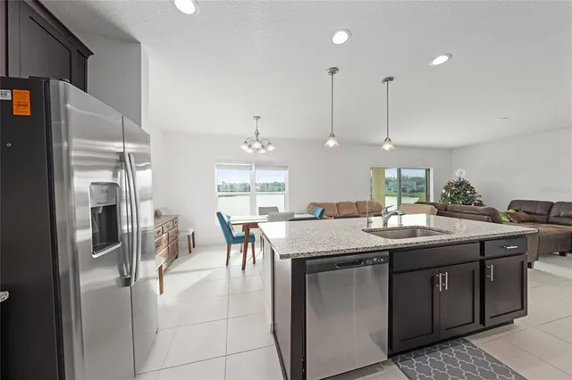 a kitchen with stainless steel appliances granite countertop a sink and a refrigerator