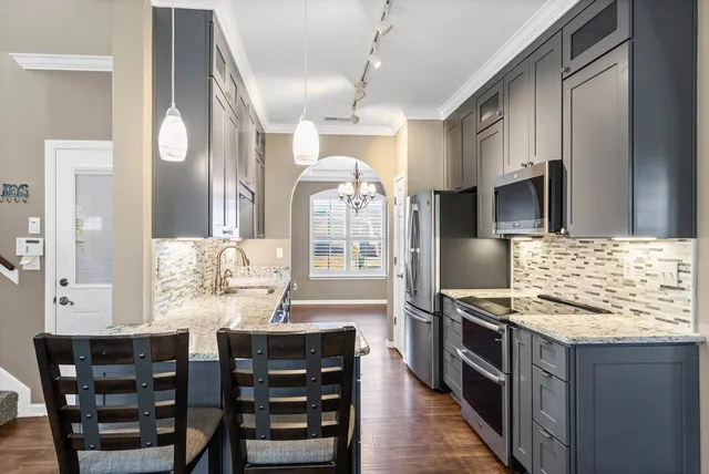 a kitchen with stainless steel appliances kitchen island granite countertop a stove and cabinets