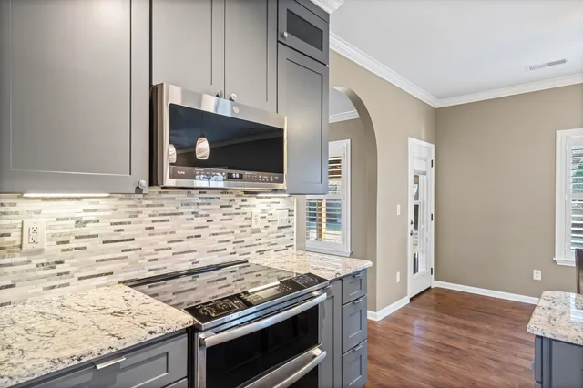 a kitchen with granite countertop a stove and a microwave