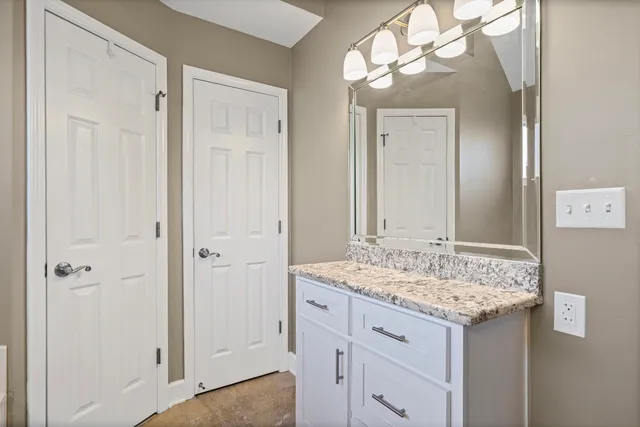 a bathroom with a granite countertop sink and a mirror