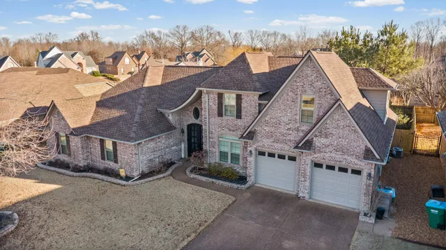 a view of a big house with a big yard and large tree