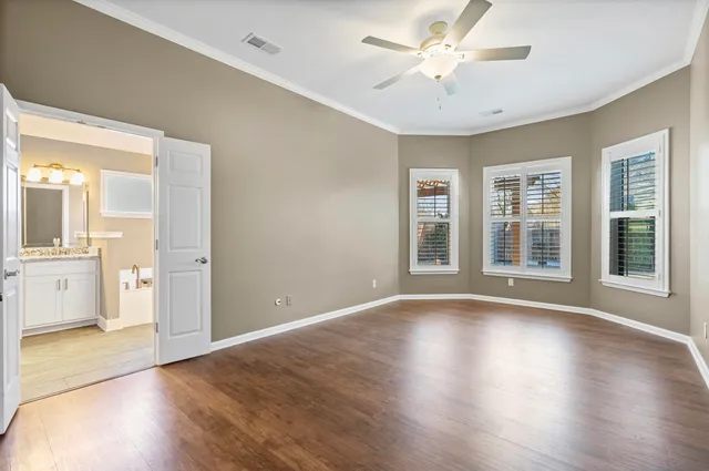 a view of an empty room with window and wooden floor