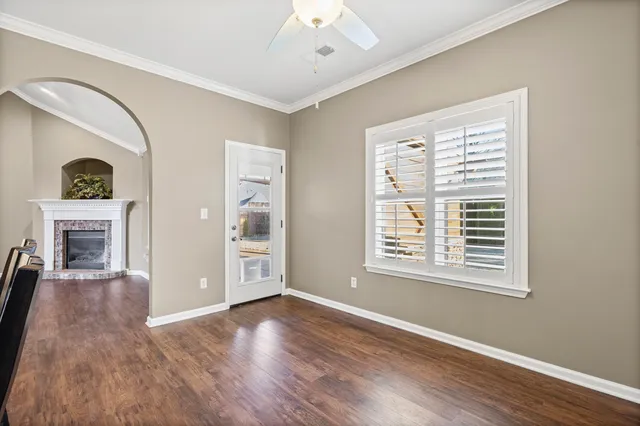 a view of an empty room with window and wooden floor