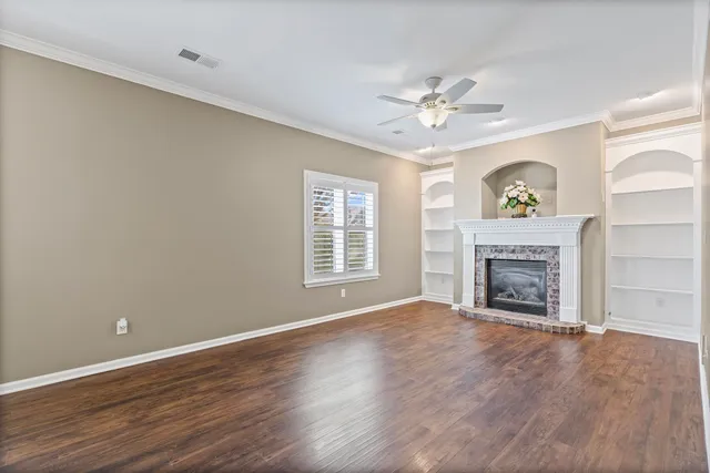 wooden floor fireplace and windows in an empty room