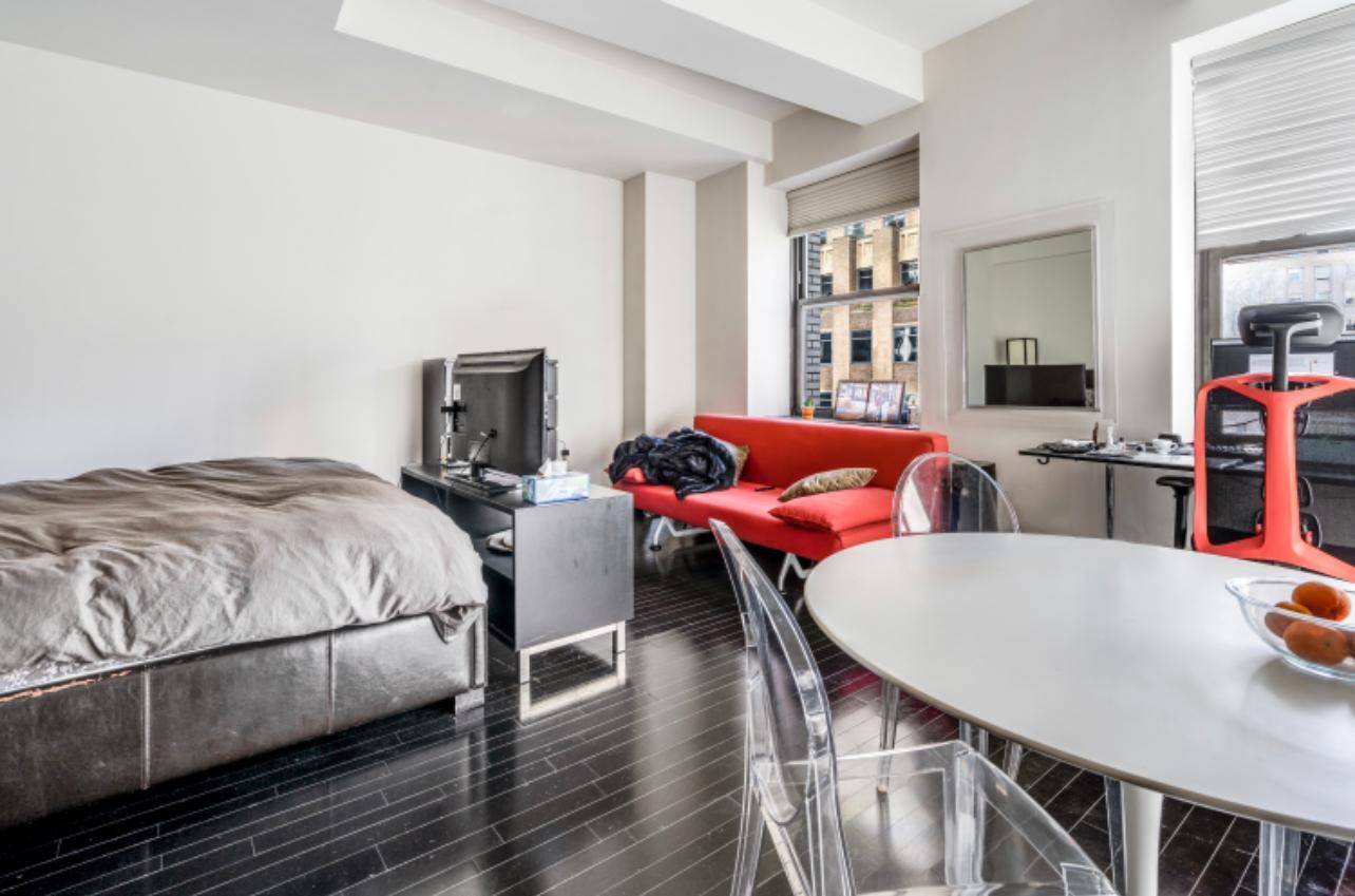 20 Pine Street, Unit 2205 Manhattan, NY 10005 - Photo 2 of 10 a living room with furniture and a wooden floor
