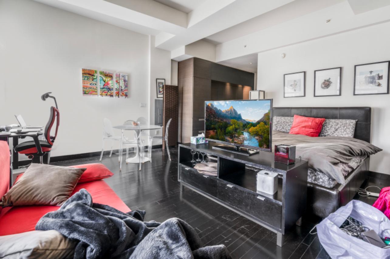 20 Pine Street, Unit 2205 Manhattan, NY 10005 - Photo 4 of 10 a living room with furniture and a flat screen tv