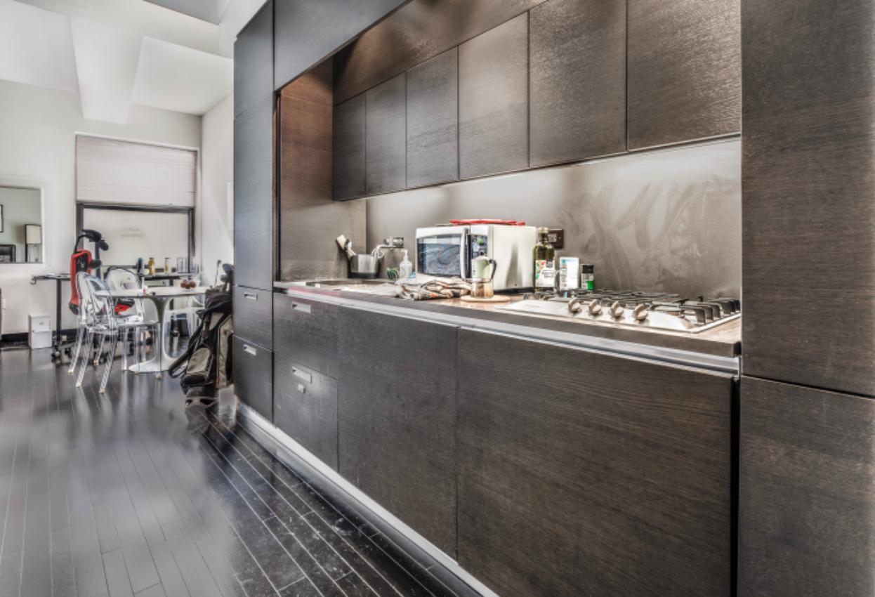 20 Pine Street, Unit 2205 Manhattan, NY 10005 - Photo 6 of 10 a kitchen with a sink and wooden cabinets