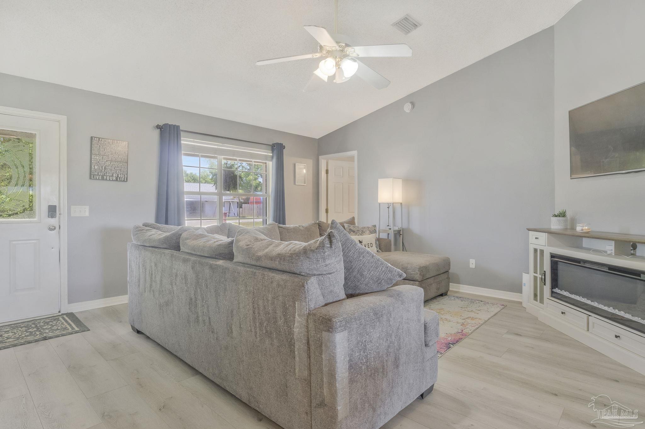 5539 Windrun Place Pace, FL 32571 - Photo 15 of 62 a living room with furniture and a flat screen tv