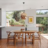 a dining room with furniture a large window and wooden floor