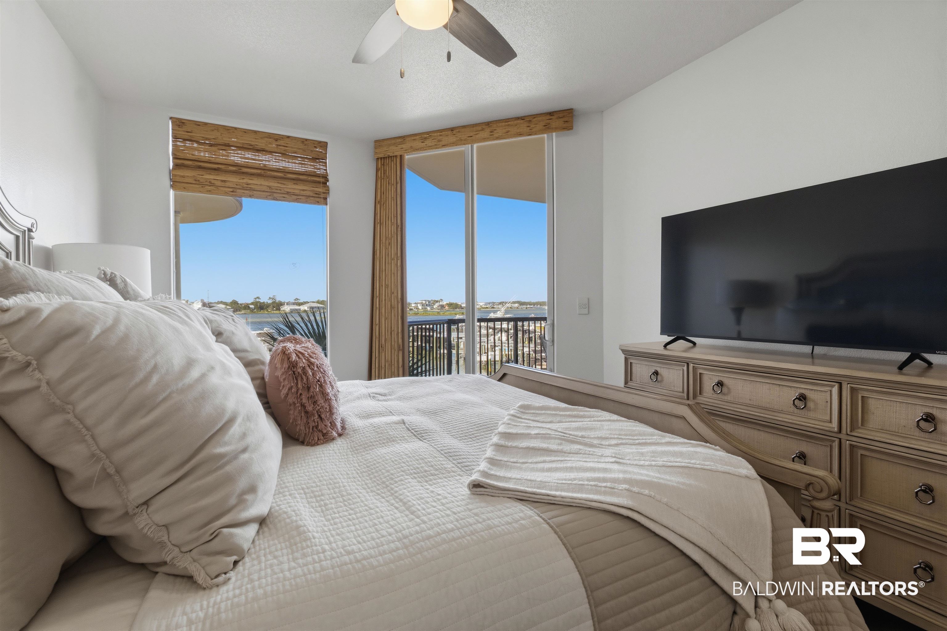 3564 Bayou Road, Unit 203 Orange Beach, AL 36561 - Photo 24 of 53 Spacious bedroom featuring expansive windows, a ceiling fan with integrated lighting, and direct access to an outdoor balcony