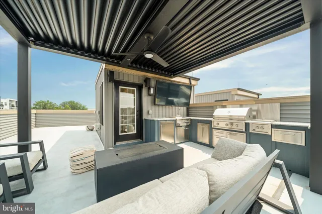 a living room with stainless steel appliances kitchen island granite countertop furniture and a large window