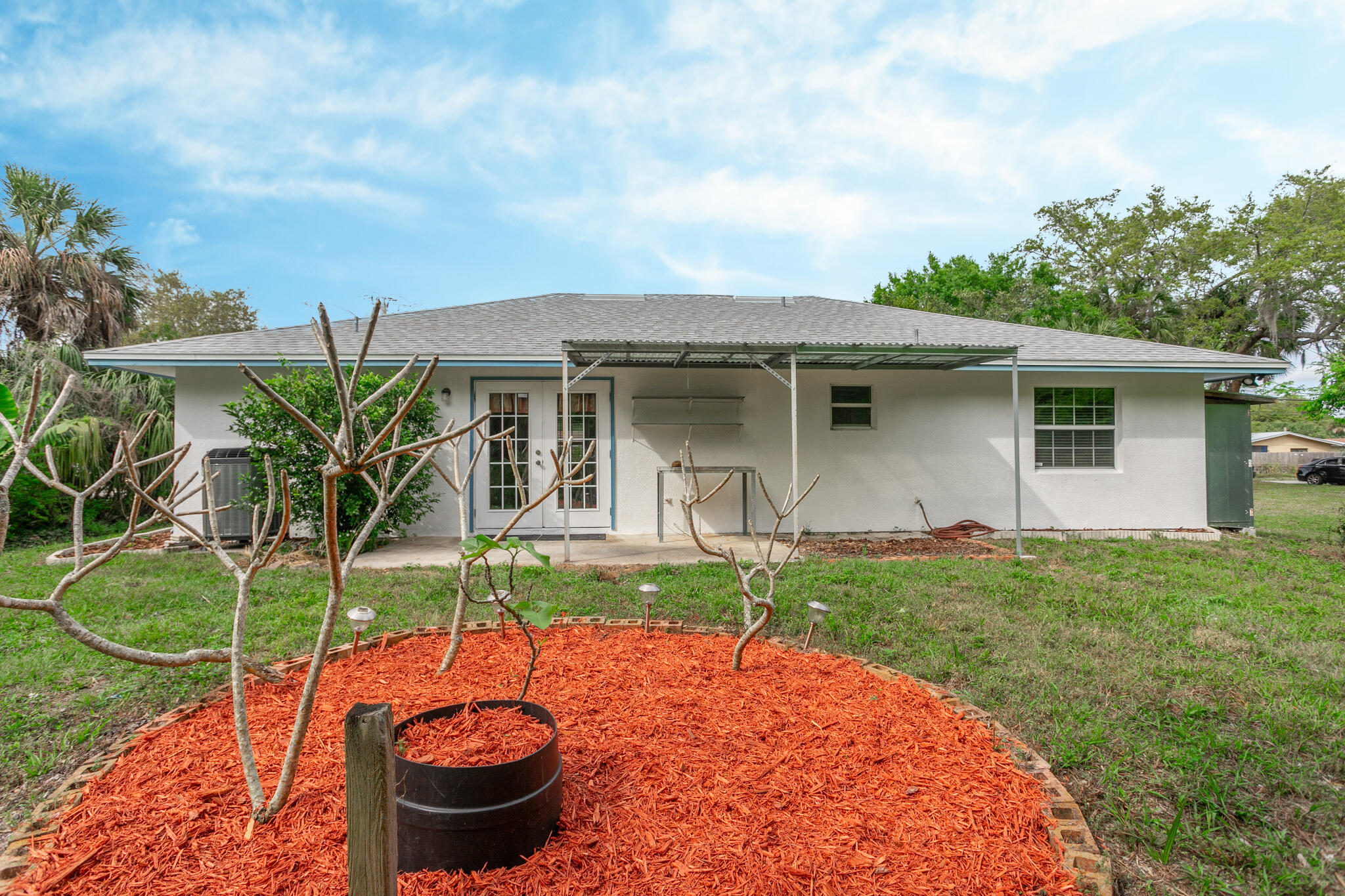 441 Lucas Road Merritt Island, FL 32953 - Photo 15 of 17 a view of a backyard with table and chairs potted plants and large tree
