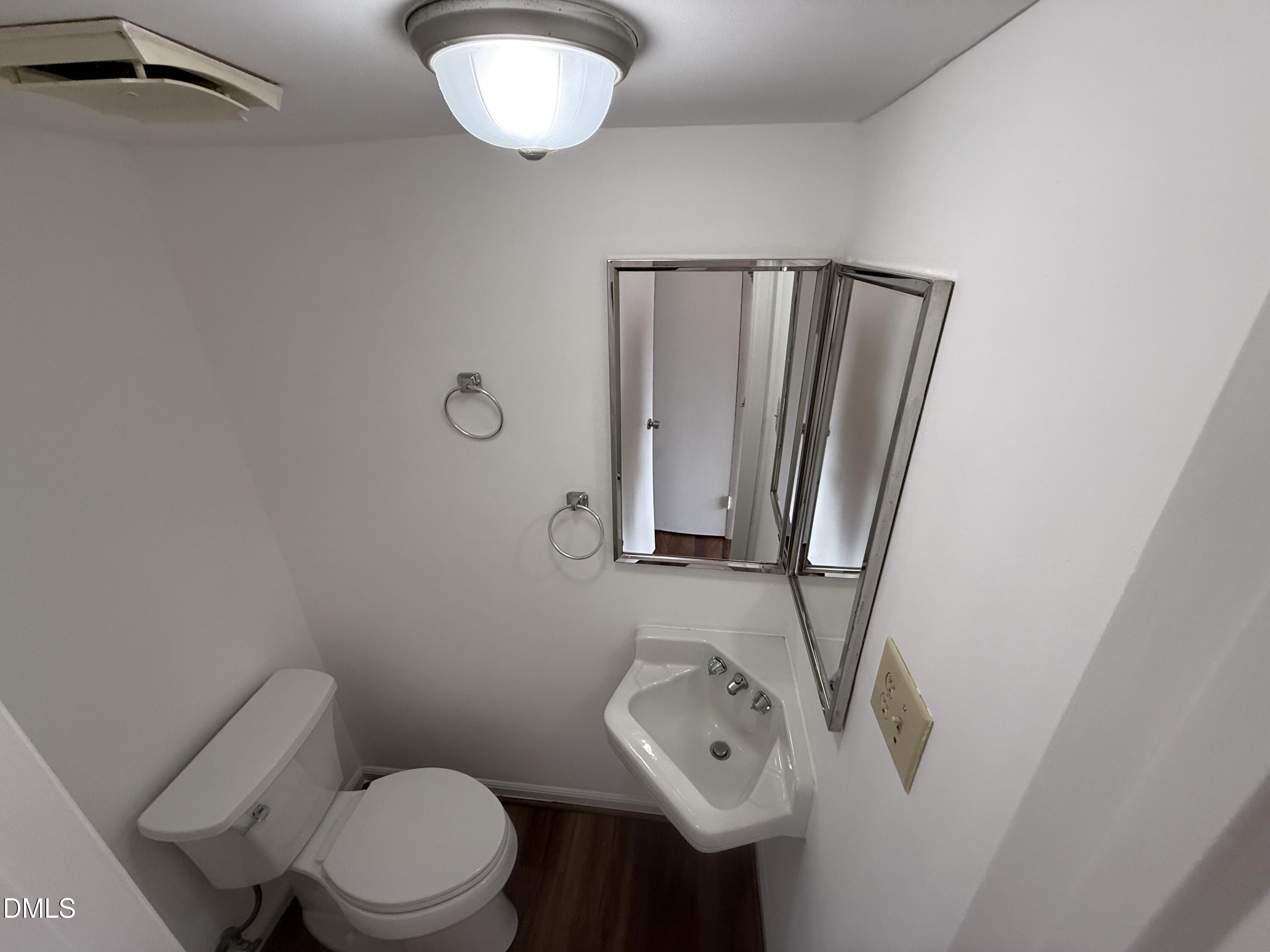 1228 Teakwood Place Raleigh, NC 27606 - Photo 17 of 30 a bathroom with a toilet sink and mirror
