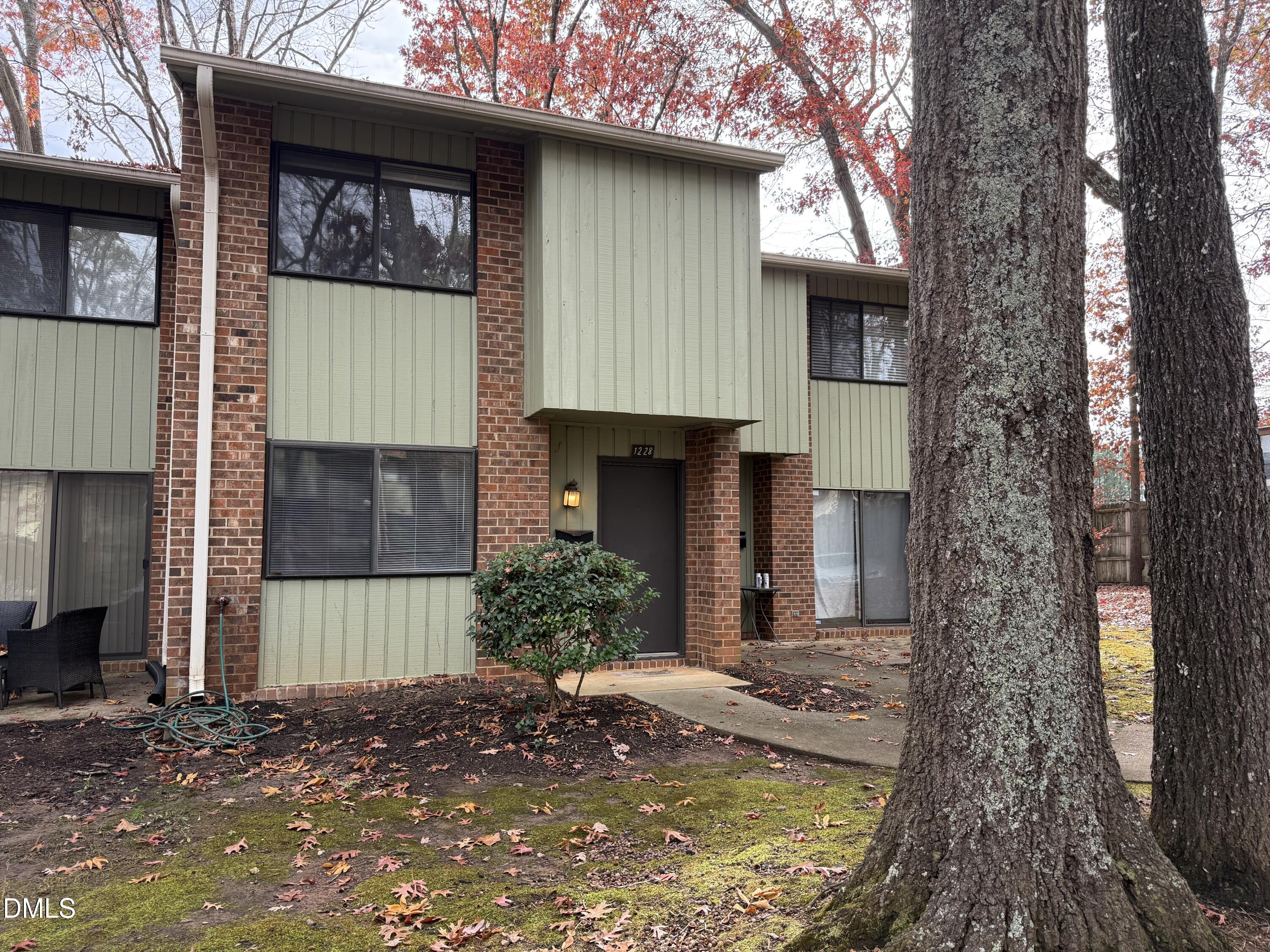 1228 Teakwood Place Raleigh, NC 27606 - Photo 2 of 30 a view of a house with a small yard plants and large tree