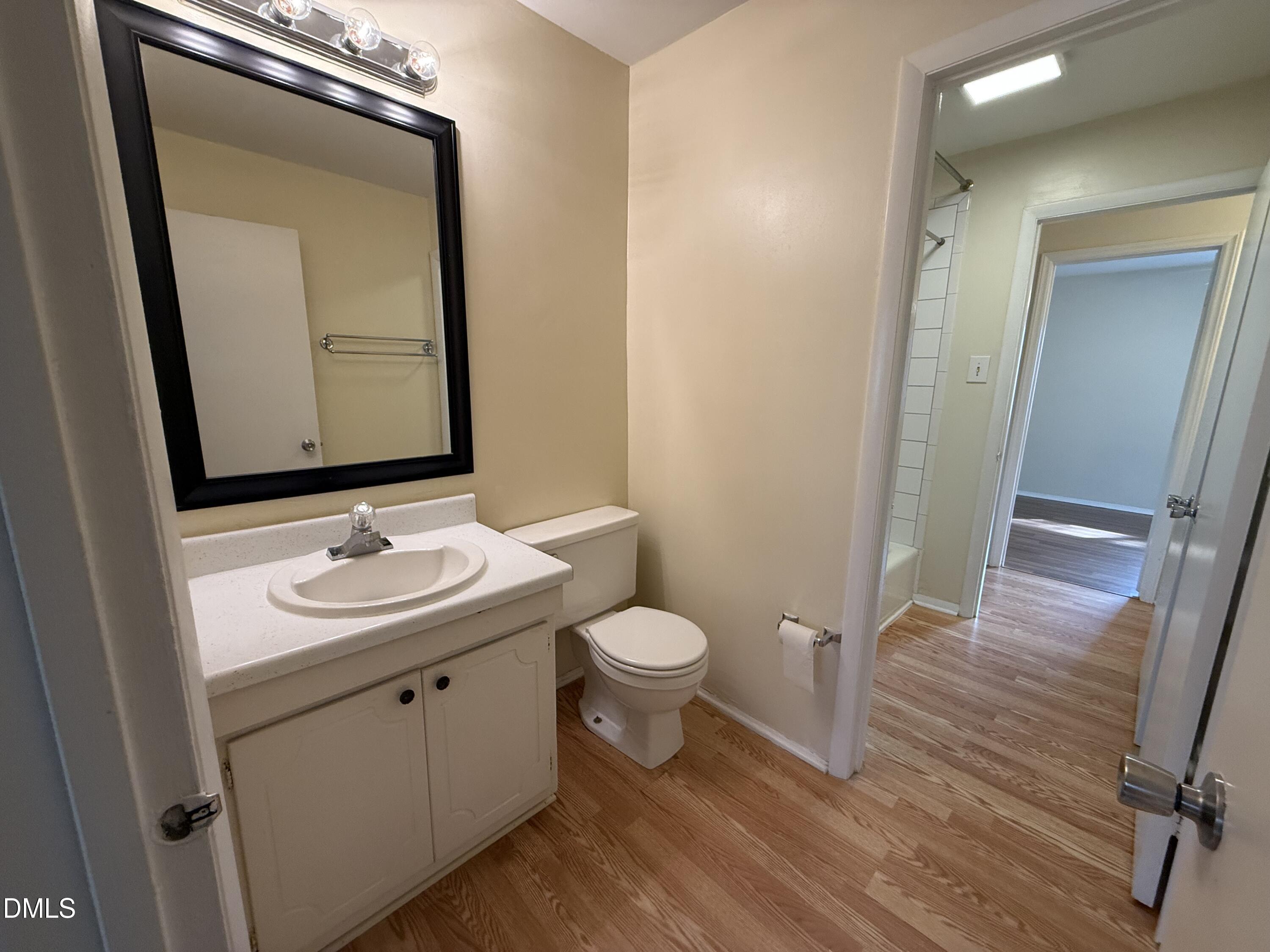 1228 Teakwood Place Raleigh, NC 27606 - Photo 23 of 30 a bathroom with a toilet a sink and mirror