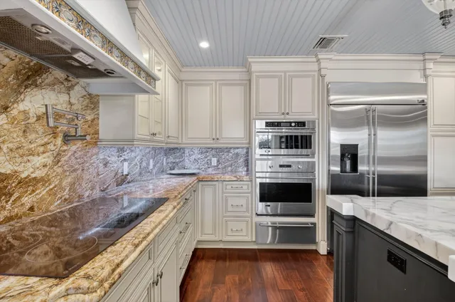 a large kitchen with kitchen island a large counter space a sink appliances and living room view