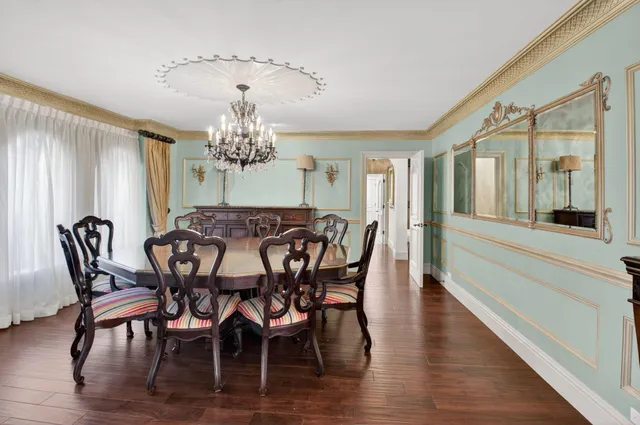a view of a dining room with furniture a chandelier and wooden floor