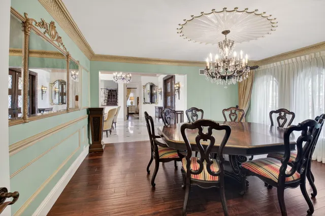 a kitchen with granite countertop a table chairs stove a sink dishwasher and cabinets with wooden floor