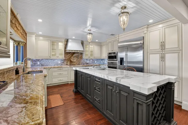 a kitchen with stainless steel appliances granite countertop a stove and a refrigerator