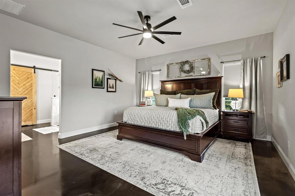979 Mitchell Road Sherman, TX 75090 - Photo 15 of 40 Bedroom featuring a barn door, a ceiling fan, and connected bathroom