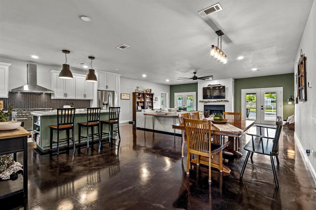 979 Mitchell Road Sherman, TX 75090 - Photo 5 of 40 Dining area featuring a fireplace, french doors, recessed lighting, and concrete flooring