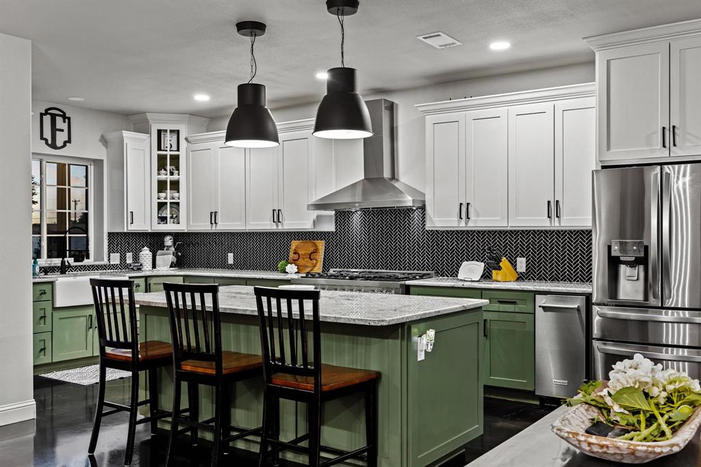 979 Mitchell Road Sherman, TX 75090 - Photo 8 of 40 Kitchen featuring green cabinetry, backsplash, a kitchen breakfast bar, stainless steel refrigerator with ice dispenser, and light stone counters