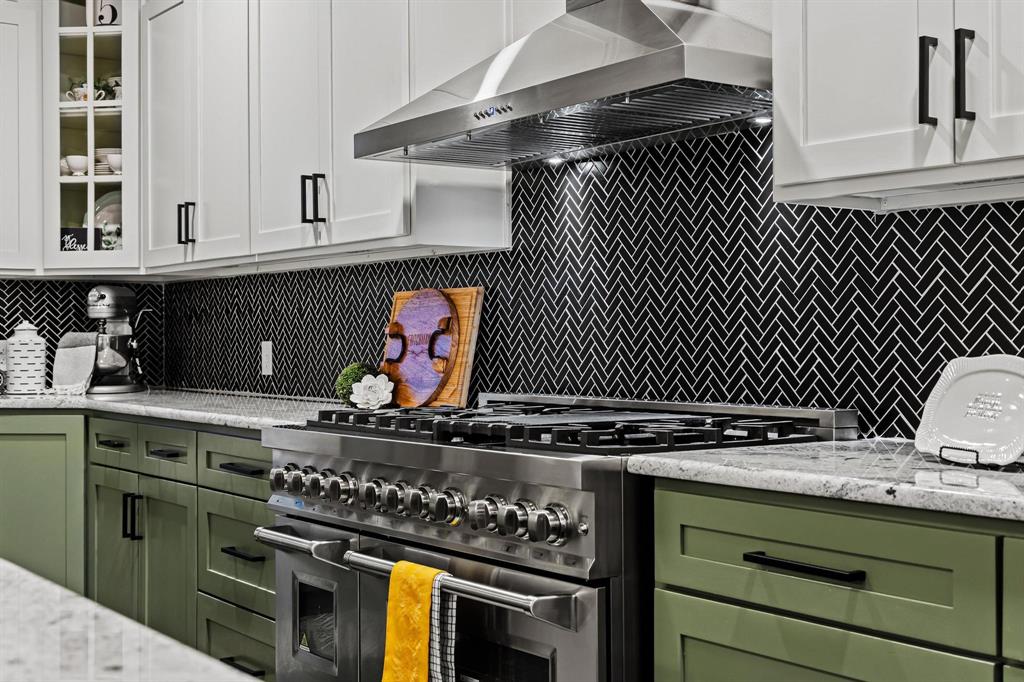 979 Mitchell Road Sherman, TX 75090 - Photo 9 of 40 Kitchen featuring green cabinets, decorative backsplash, glass insert cabinets, and high end stainless steel range
