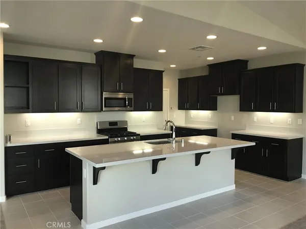 a kitchen with kitchen island sink stainless steel appliances and cabinets