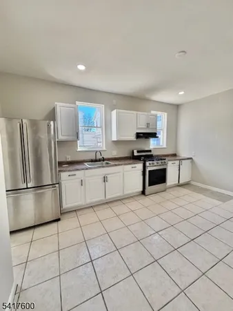 a kitchen with stainless steel appliances granite countertop a refrigerator sink and stove