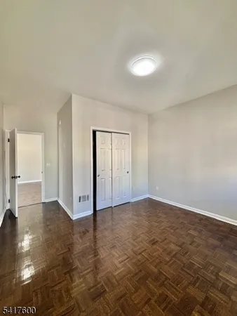 an empty room with floor to ceiling window and closet