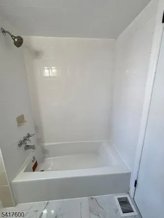 a bath tub sitting next to a white sink
