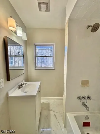 a bathroom with a sink a tub and a mirror