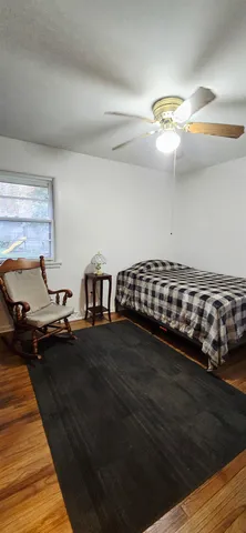 a bedroom with a bed and wooden floor