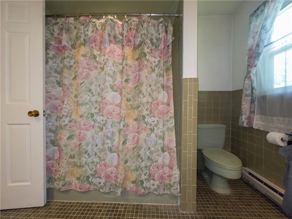 2516 Rachael Lane Orefield, PA 18069 - Photo 25 of 45 A window-lit bathroom featuring retro tiling and a floral shower curtain.