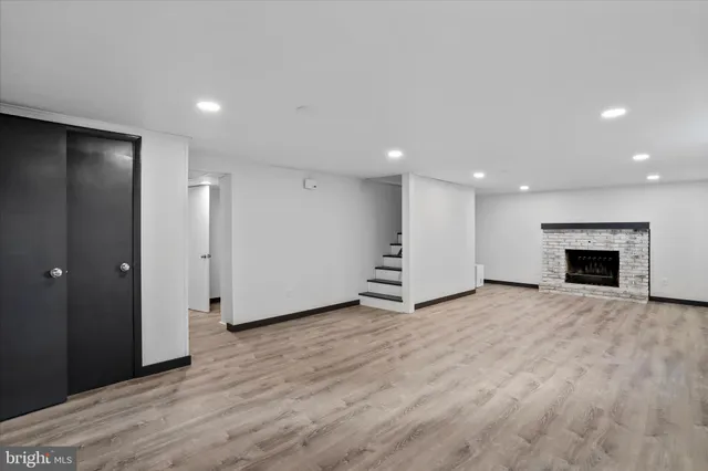 an empty room with wooden floor and fireplace
