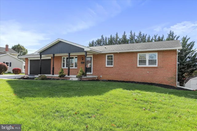a front view of a house with a yard fire pit and outdoor seating