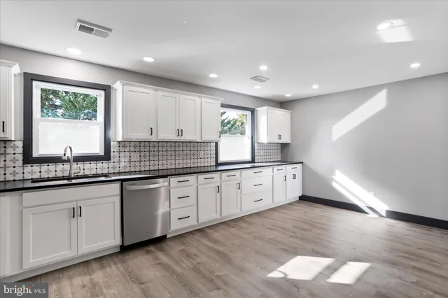 a large kitchen with granite countertop a large window a sink and stainless steel appliances