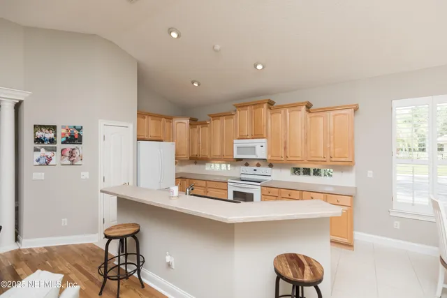a dining room with furniture and large windows