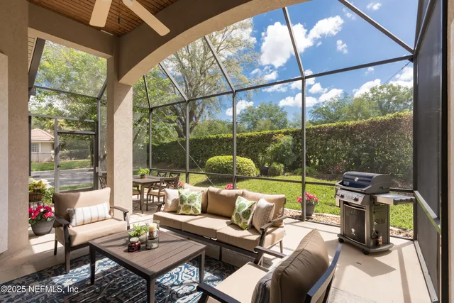 a living room with patio furniture and a floor to ceiling window