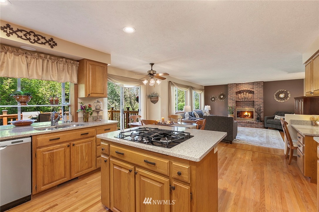 4933 211th Street Southeast Bothell, WA 98021 - Photo 4 of 25 a kitchen with a stove a sink dishwasher and a refrigerator with wooden floor