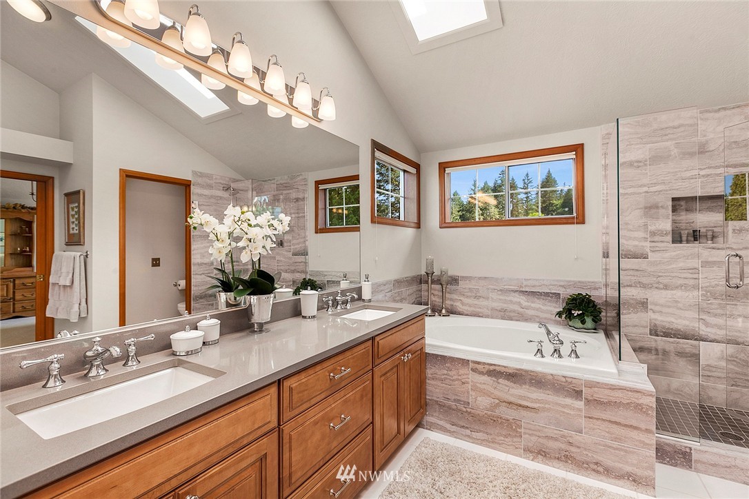 4933 211th Street Southeast Bothell, WA 98021 - Photo 8 of 25 a bathroom with a sink a large mirror and a bathtub