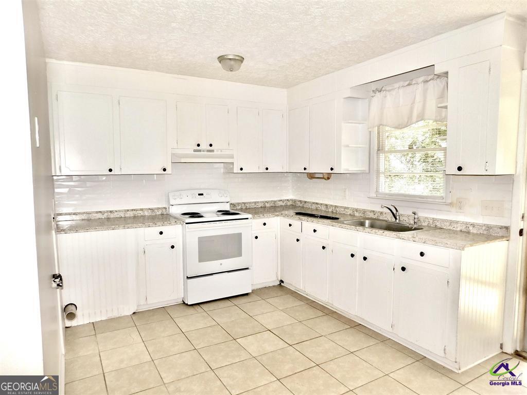 304 Wall Street Warner Robins, GA 31088 - Photo 2 of 4 a kitchen with granite countertop white cabinets and white appliances