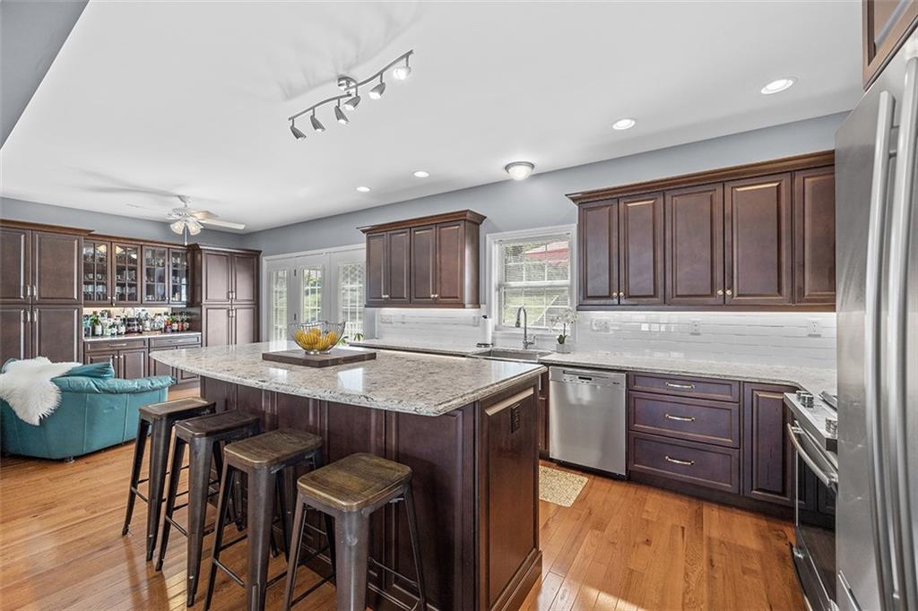 11 Natchez Street Pittsburgh, PA 15211 - Photo 10 of 25 a kitchen with a stove a sink a refrigerator dining table and chairs