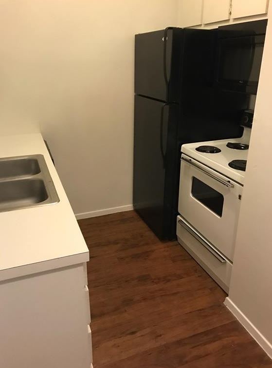 2604 Salado Street, Unit 104 Austin, TX 78705 - Photo 4 of 8 a kitchen with a refrigerator and a stove