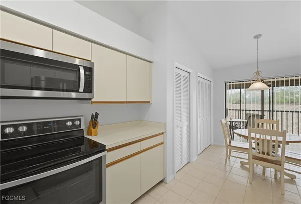 a kitchen with stainless steel appliances a stove a microwave and white cabinets