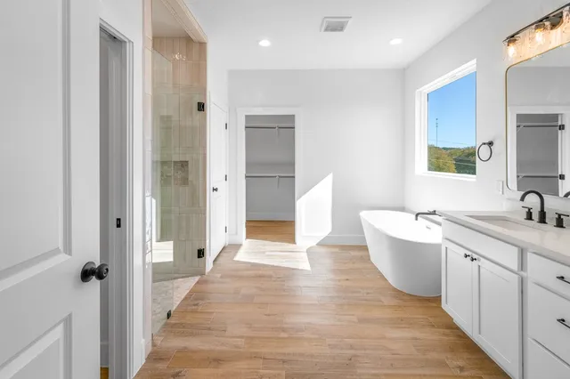 a bathroom with a tub sink and mirror